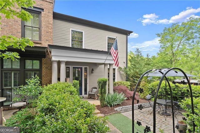 back of property with a patio and brick siding
