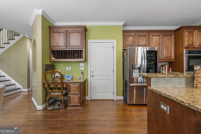 kitchen with crown molding, appliances with stainless steel finishes, arched walkways, dark wood finished floors, and baseboards