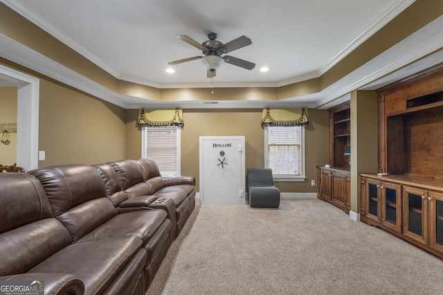 carpeted living area featuring crown molding, ceiling fan, baseboards, and a raised ceiling