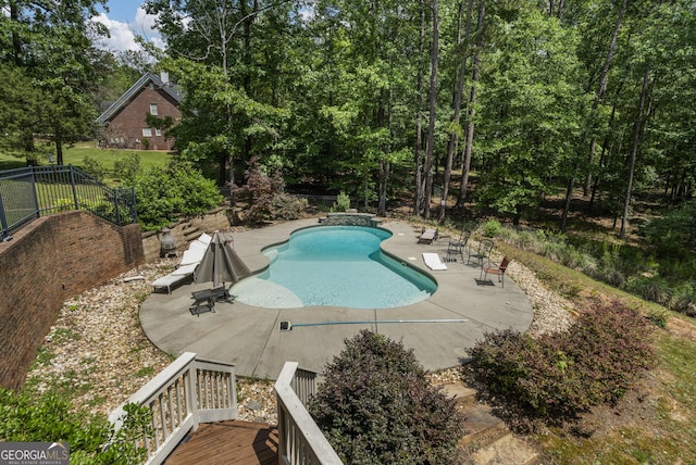 outdoor pool featuring a patio and fence