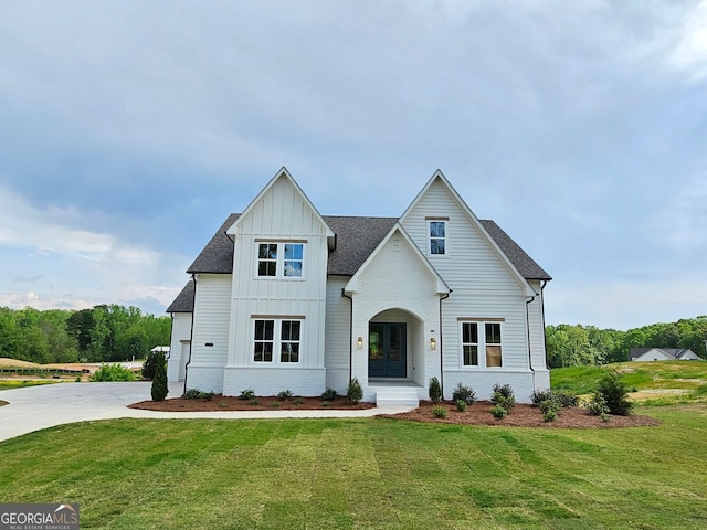 modern inspired farmhouse with a front lawn, driveway, roof with shingles, and board and batten siding
