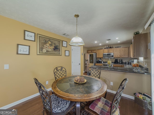 dining area featuring dark wood-type flooring, visible vents, baseboards, and recessed lighting