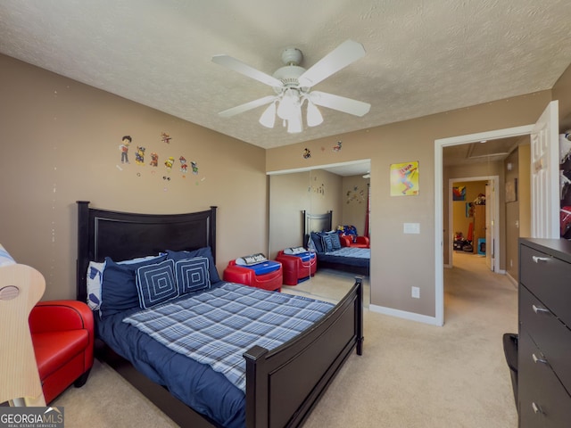 bedroom featuring attic access, a textured ceiling, light colored carpet, and ceiling fan
