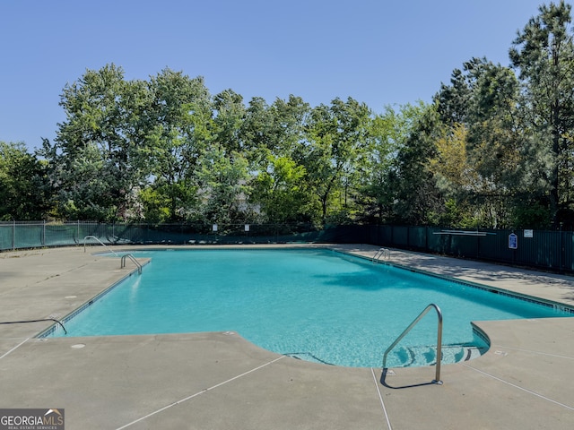 pool with fence and a patio