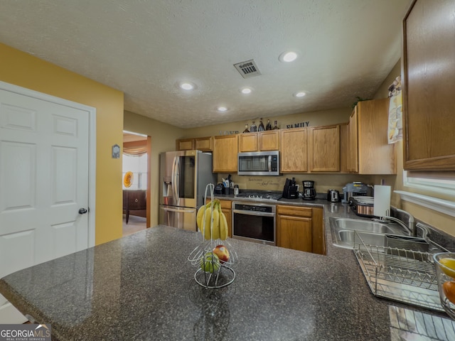 kitchen with recessed lighting, stainless steel appliances, visible vents, a sink, and a peninsula