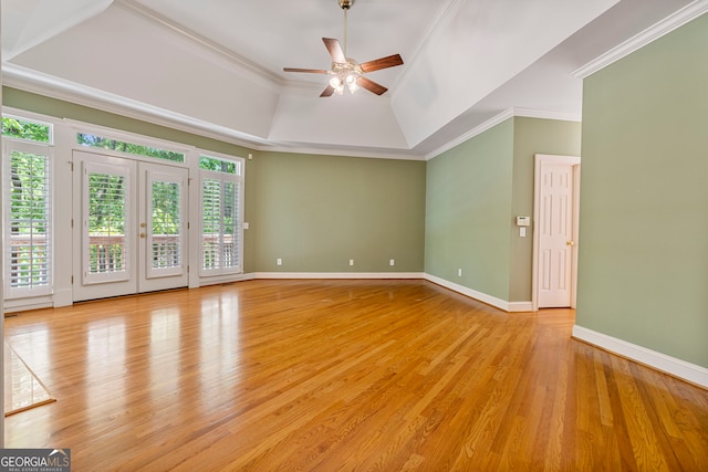unfurnished room featuring light wood-style floors, baseboards, ceiling fan, and a tray ceiling