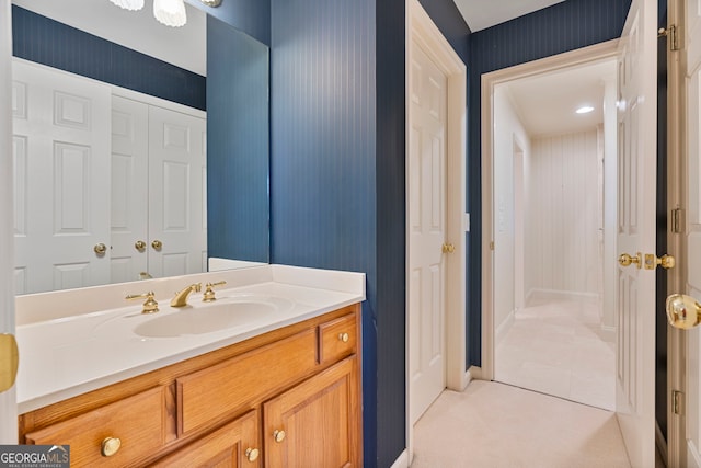 bathroom featuring vanity and wallpapered walls