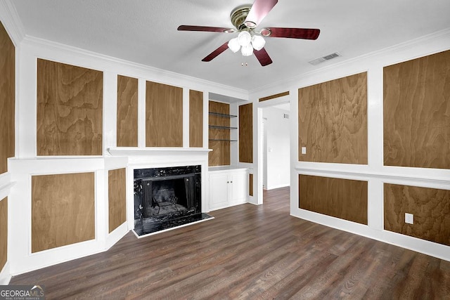 unfurnished living room with ceiling fan, wood finished floors, a high end fireplace, visible vents, and ornamental molding