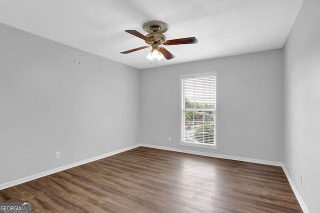 spare room with baseboards, ceiling fan, and wood finished floors