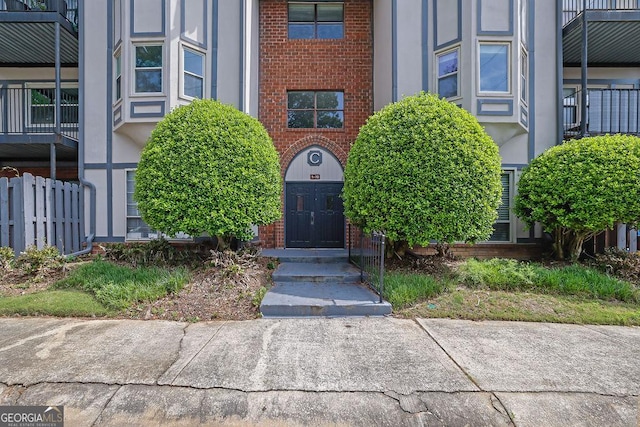 doorway to property featuring stucco siding