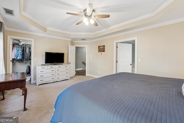 1236 Brickton Dr NW, Atlanta, GA 30318 - bedroom featuring a tray ceiling, light carpet, crown molding, a walk in closet, and a ceiling fan