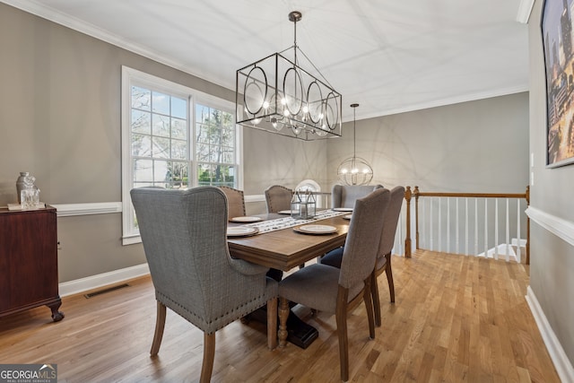 1236 Brickton Dr NW, Atlanta, GA 30318 - dining space featuring a chandelier, crown molding, light wood-style floors, and baseboards