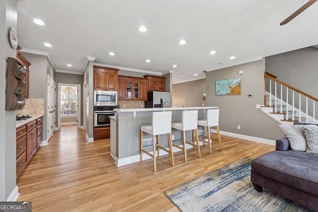 1236 Brickton Dr NW, Atlanta, GA 30318 - kitchen featuring appliances with stainless steel finishes, crown molding, a breakfast bar area, backsplash, and brown cabinets