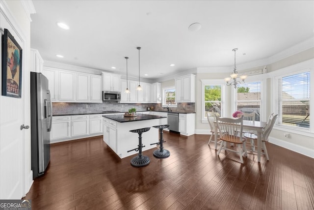 5950 Hidden Ridge Ct, Cumming, GA 30028 - kitchen with appliances with stainless steel finishes, dark countertops, tasteful backsplash, a center island, and white cabinets