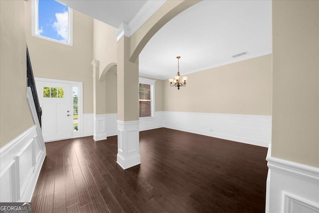 5950 Hidden Ridge Ct, Cumming, GA 30028 - foyer entrance with arched walkways, a chandelier, wainscoting, ornamental molding, and healthy amount of natural light