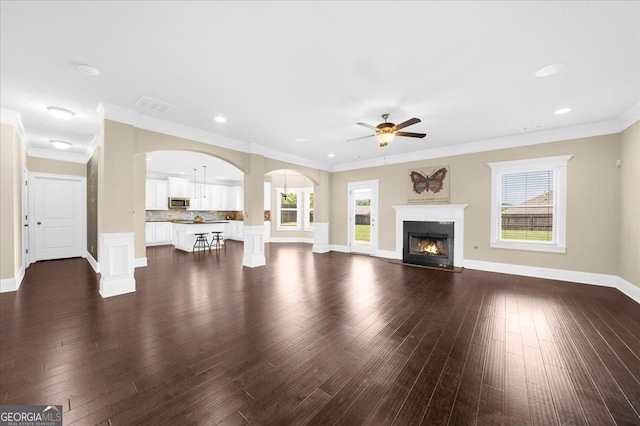 5950 Hidden Ridge Ct, Cumming, GA 30028 - unfurnished living room with ceiling fan, arched walkways, dark wood-style flooring, recessed lighting, and crown molding