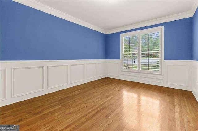 51 Sagemont Ct, Acworth, GA 30101 - unfurnished room with a decorative wall, crown molding, a wainscoted wall, and wood finished floors