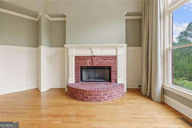51 Sagemont Ct, Acworth, GA 30101 - unfurnished living room featuring wood finished floors, a decorative wall, crown molding, and a wainscoted wall