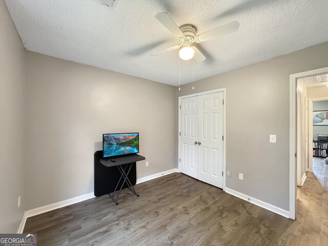 bedroom with attic access, wood finished floors, a closet, and baseboards