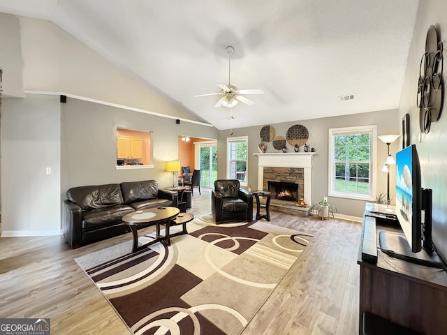 living area with ceiling fan, lofted ceiling, light wood finished floors, and plenty of natural light