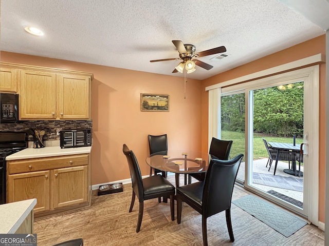 dining space featuring baseboards, visible vents, a textured ceiling, and ceiling fan