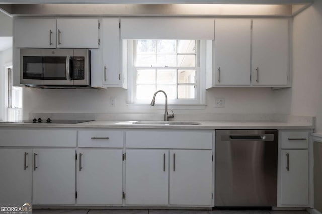 kitchen featuring appliances with stainless steel finishes, a sink, and light countertops