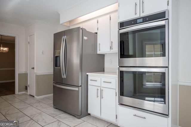 kitchen with a chandelier, marble finish floor, white cabinetry, light countertops, and appliances with stainless steel finishes