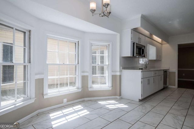kitchen featuring a chandelier, stainless steel appliances, light countertops, and plenty of natural light