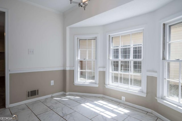 unfurnished dining area with visible vents, marble finish floor, baseboards, and ornamental molding