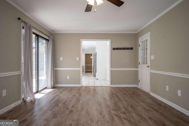 empty room featuring wood finished floors, visible vents, baseboards, and ceiling fan