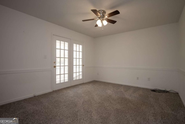 carpeted empty room featuring ceiling fan and baseboards