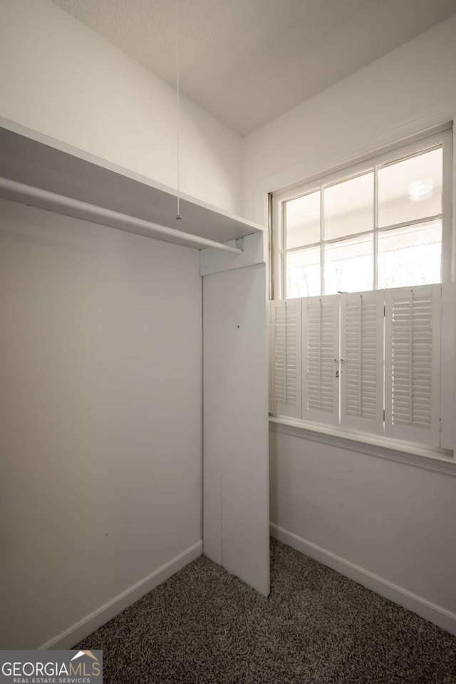 carpeted empty room with baseboards and ceiling fan