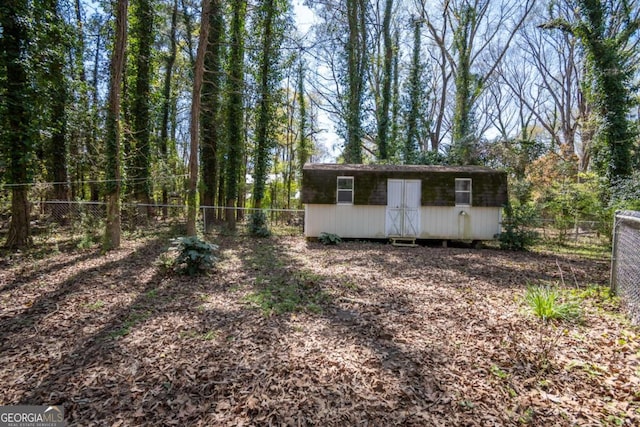 view of side of property with a chimney, a balcony, roof with shingles, and concrete driveway