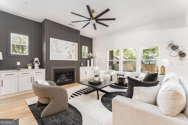 156 Martha Ave NE, Atlanta, GA 30317 - living room featuring a ceiling fan, light wood-type flooring, a glass covered fireplace, and healthy amount of natural light