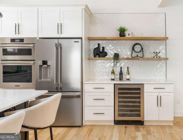 156 Martha Ave NE, Atlanta, GA 30317 - indoor dry bar featuring appliances with stainless steel finishes, wine cooler, decorative backsplash, and light wood finished floors