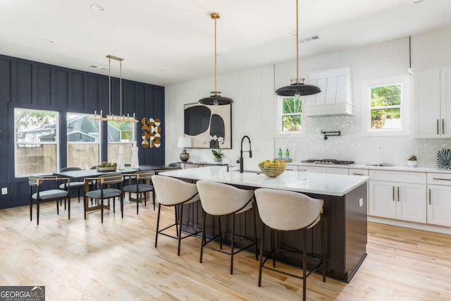 156 Martha Ave NE, Atlanta, GA 30317 - kitchen featuring a sink, light countertops, tasteful backsplash, white cabinets, and light wood-style floors