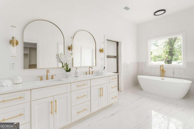 156 Martha Ave NE, Atlanta, GA 30317 - full bathroom featuring a wainscoted wall, double vanity, a freestanding bath, and marble finish floors
