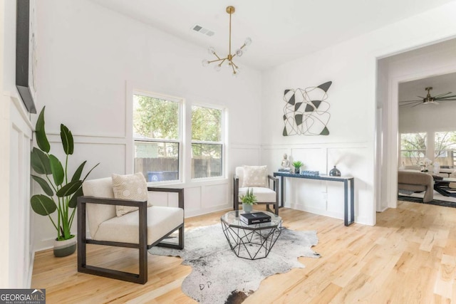 156 Martha Ave NE, Atlanta, GA 30317 - sitting room with a decorative wall, a chandelier, wood finished floors, and a wainscoted wall