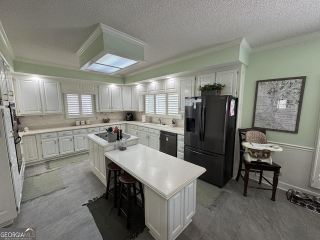 1323 Fairway Dr, Elberton, GA 30635 - kitchen with white cabinets, a sink, black appliances, and a kitchen island