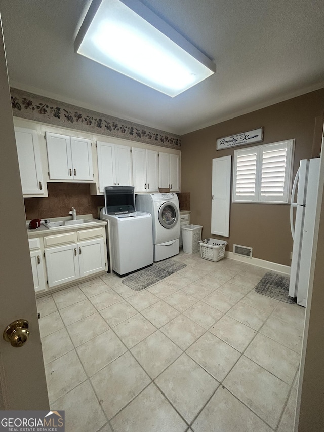 1323 Fairway Dr, Elberton, GA 30635 - laundry room featuring visible vents, light tile patterned floors, a sink, separate washer and dryer, and cabinet space
