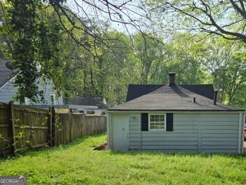 2016 Conrad Ave SE, Atlanta, GA 30315 - back of house featuring a lawn, fence, and a chimney