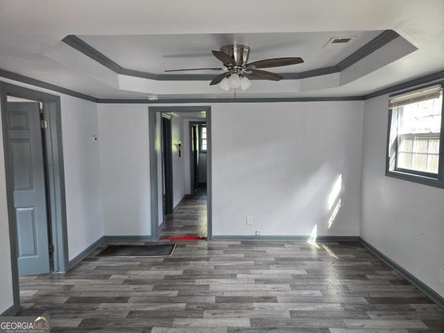 2016 Conrad Ave SE, Atlanta, GA 30315 - empty room featuring a tray ceiling, wood finished floors, a ceiling fan, and baseboards