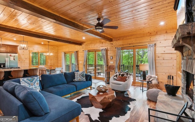 living room featuring wood walls, beam ceiling, hardwood / wood-style flooring, wooden ceiling, and a fireplace