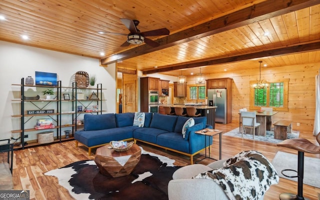 living area with a chandelier, beamed ceiling, light wood-style floors, wooden ceiling, and a ceiling fan
