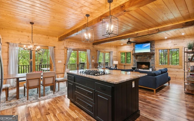 kitchen with stainless steel gas stovetop, wood ceiling, dark cabinets, a chandelier, and light wood-type flooring