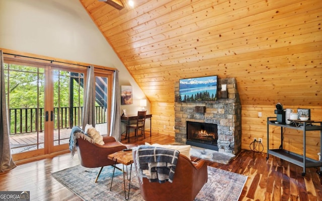 living room featuring wood ceiling, wooden walls, a stone fireplace, hardwood / wood-style floors, and french doors