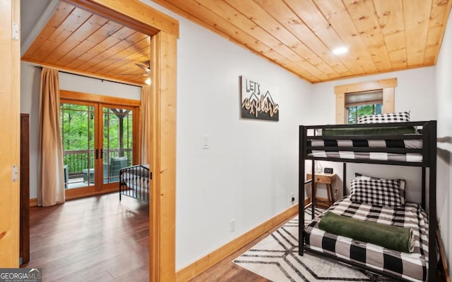 bedroom with wooden ceiling, wood finished floors, access to outside, multiple windows, and baseboards