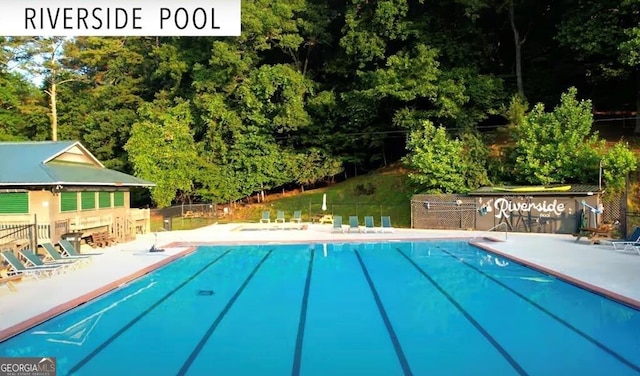 community pool featuring fence and a patio area