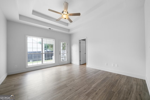 3047 Standing Rock Ct, Lithia Springs, GA 30122 - spare room with baseboards, a ceiling fan, wood finished floors, and a tray ceiling