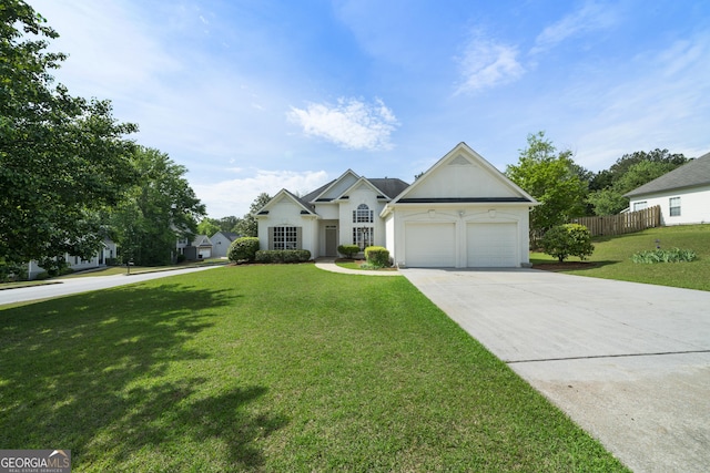 3047 Standing Rock Ct, Lithia Springs, GA 30122 - view of front of home featuring fence, stucco siding, driveway, a front yard, and a garage
